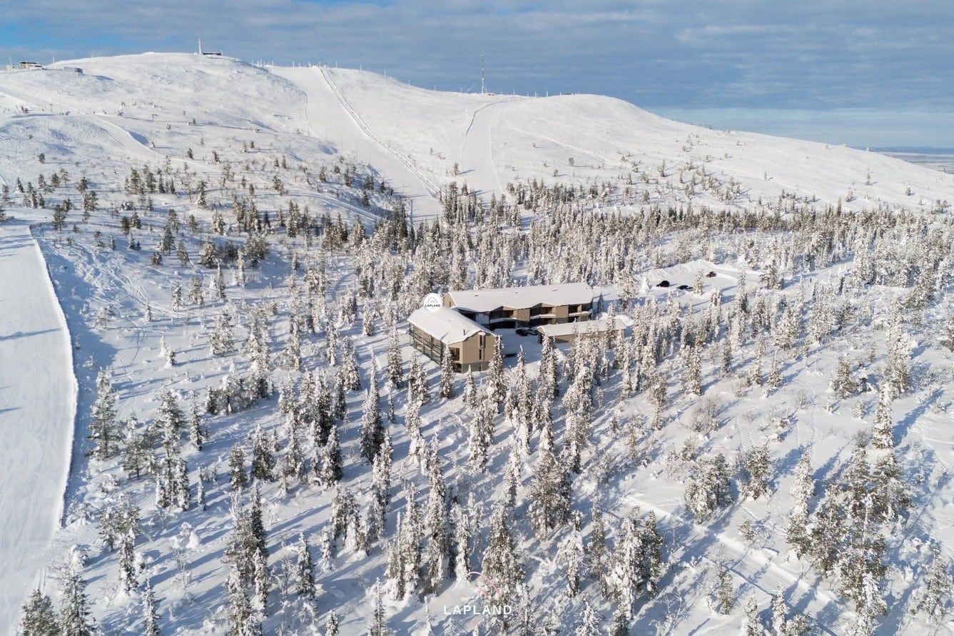 Utsuvaara Retreat ja rinne lumisessa maisemassa, taustalla Levitunturi